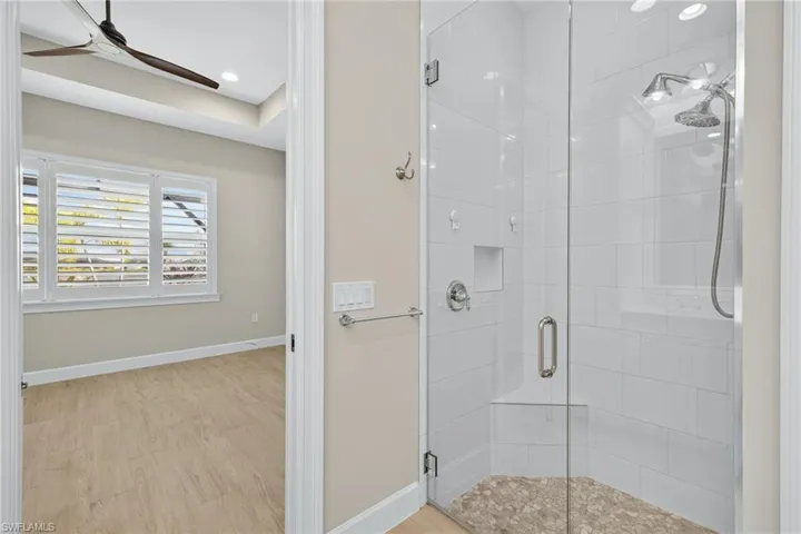 Full bathroom featuring a shower stall, light wood-style floors, a ceiling fan, and recessed lighting