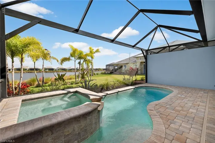 View of pool with a sunroom, a pool with connected hot tub, a residential view, a lanai, and a patio