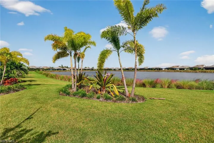 View of grassy yard featuring a water view and a residential view