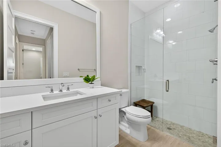 Bathroom with vanity, a shower stall, and light wood-style floors