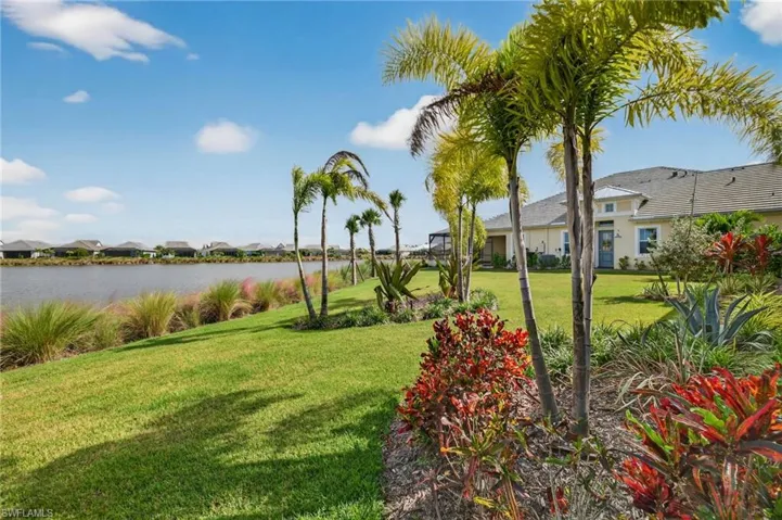 View of green lawn featuring a water view and a residential view