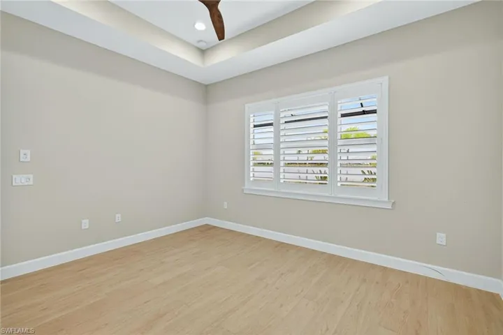 Spare room featuring light wood-style flooring, a tray ceiling, and recessed lighting