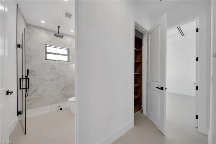 Bathroom featuring a marble finish shower and recessed lighting