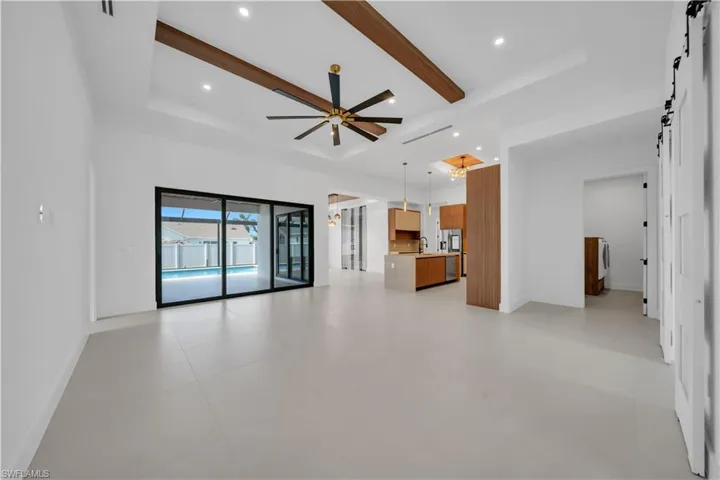 Unfurnished living room with a barn door, a ceiling fan, and recessed lighting