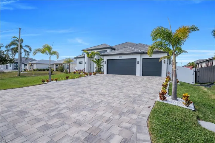 Prairie-style house with a front yard, a gate, driveway, a garage, and stucco siding