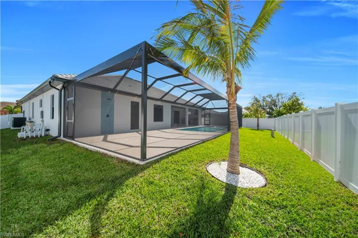Rear view of property featuring a sunroom, glass enclosure, a fenced backyard, a patio, and stucco siding
