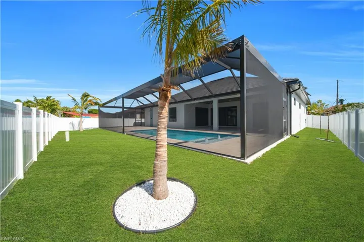 Back of house featuring a sunroom, a fenced backyard, glass enclosure, and a patio area