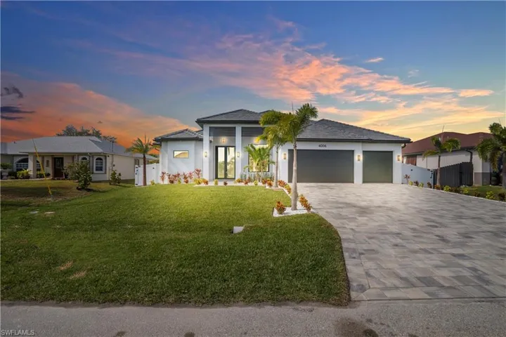 Prairie-style home with a yard, decorative driveway, a garage, and stucco siding