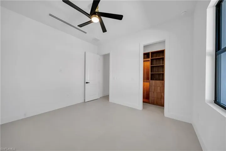 Unfurnished bedroom featuring finished concrete floors and ceiling fan
