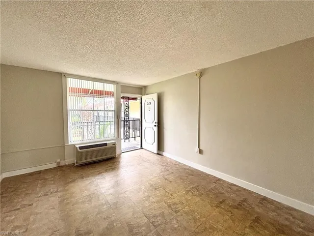 Unfurnished room with a textured ceiling and a wall mounted AC