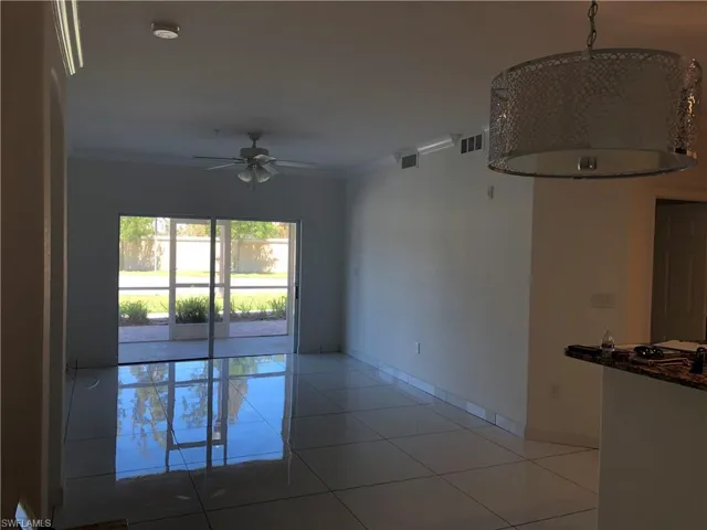 Spacious interior with large format tile flooring and a sliding glass door providing access to an outdoor patio