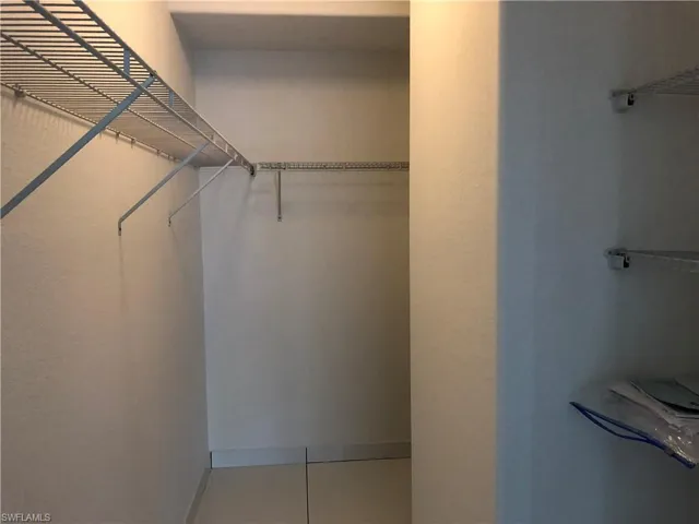 Spacious walk-in closet featuring wire shelving and hanging rods