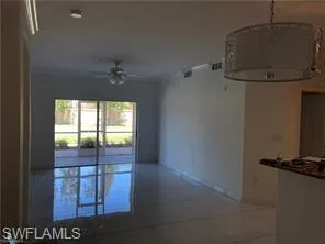 Spacious interior featuring large format tile flooring, crown molding, and recessed lighting