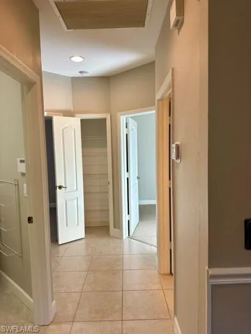 Corridor with light tile patterned flooring