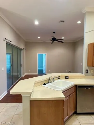 Kitchen with dishwasher, ceiling fan, sink, and light tile patterned flooring