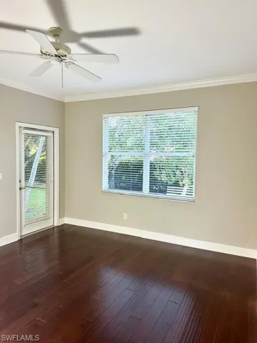 Spare room with crown molding, hardwood / wood-style flooring, and ceiling fan