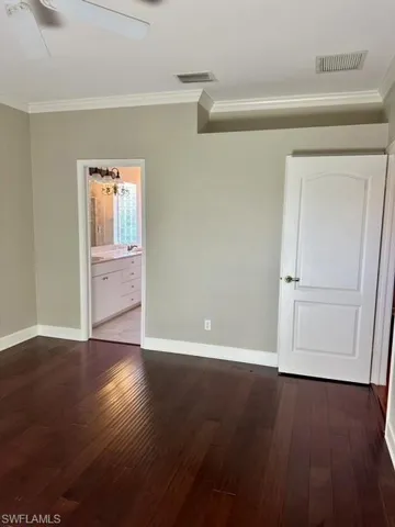 Spare room with ceiling fan, wood-type flooring, and ornamental molding
