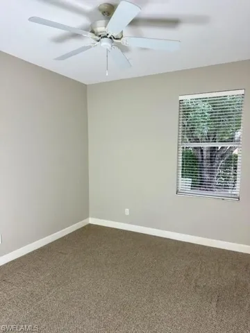 Unfurnished room featuring carpet flooring and ceiling fan