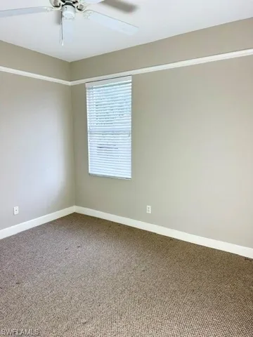 Carpeted empty room with ceiling fan