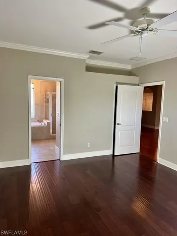 Unfurnished room with ceiling fan, ornamental molding, and dark tile patterned floors