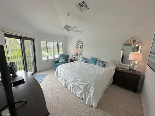 Bedroom featuring light carpet, access to outside, lofted ceiling, and ceiling fan
