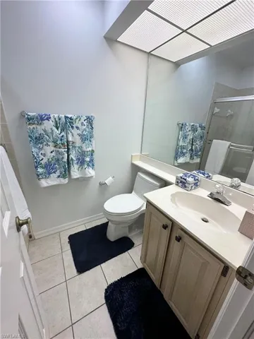 Bathroom with vanity, light tile patterned floors, and a shower stall