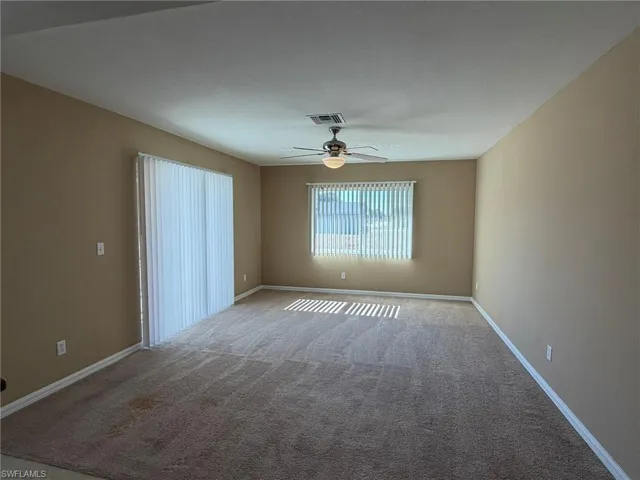 Unfurnished room with ceiling fan and carpet