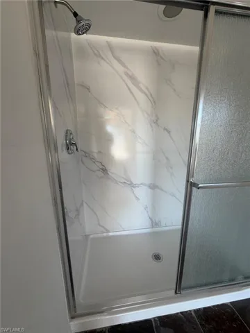 Bathroom featuring a marble finish shower