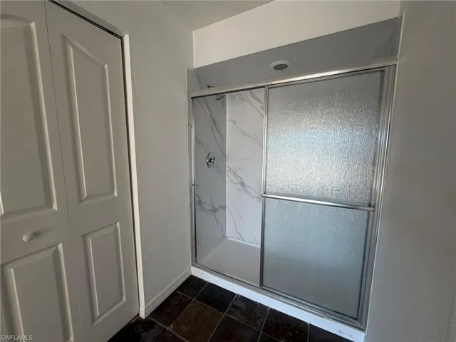 Full bathroom with a marble finish shower