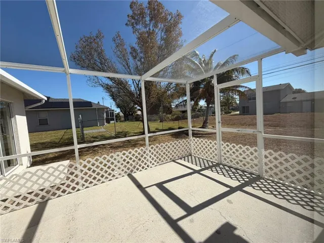 Unfurnished sunroom featuring a patio and a residential view