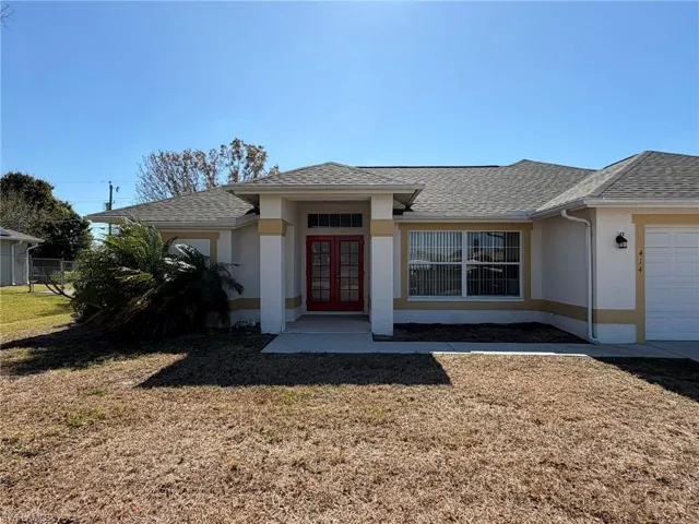View of front of house with french doors, stucco siding, roof with shingles, and an attached garage