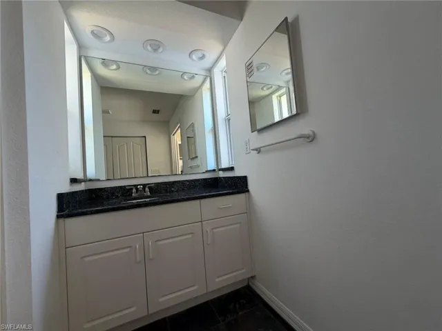 Bathroom with vanity and a textured wall
