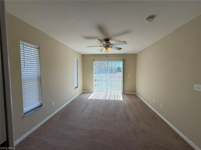 Spare room featuring a ceiling fan and carpet