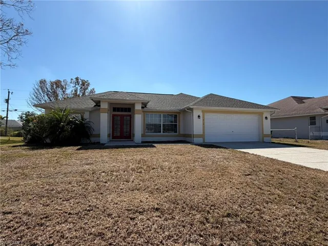 View of front of home with stucco siding, concrete driveway, french doors, a garage, and a shingled roof