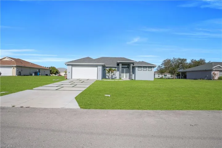 Prairie-style house with a front lawn, concrete driveway, and an attached garage