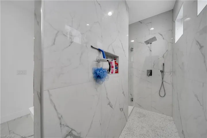 Full bathroom featuring a marble finish shower and marble finish flooring