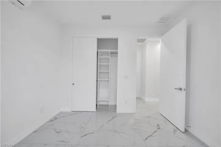 Unfurnished bedroom with light marble finish flooring and a closet