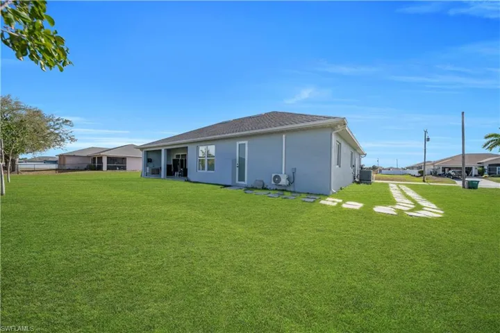 Rear view of property with a yard and stucco siding