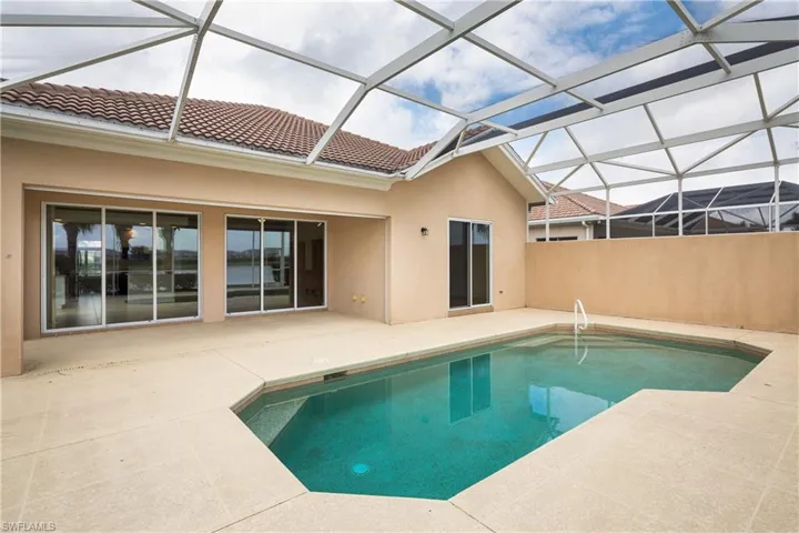 Outdoor pool featuring glass enclosure and a patio