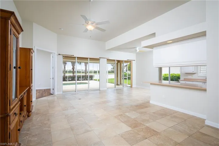 Great room opening up to the kitchen featuring plenty of natural light, a high ceiling and gorgeous view of lake
