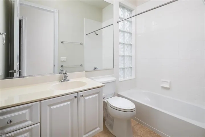 Guest bathroom featuring bathtub / shower combination, vanity, and toilet