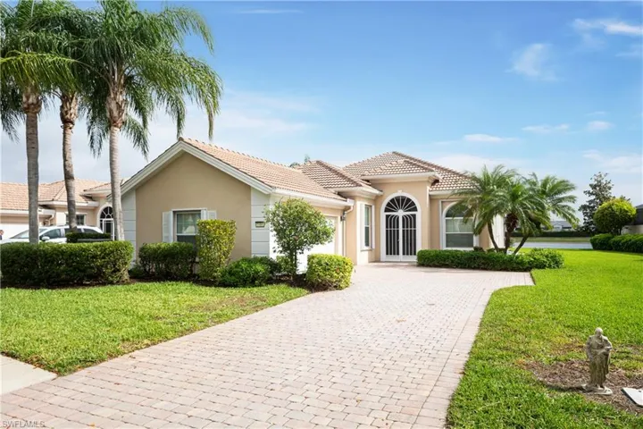 Mediterranean / spanish-style home featuring decorative driveway, an attached garage, a front yard, and stucco siding