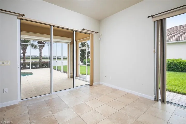 Open dining area adjacent to kitchen and great room with view of pool and lake.