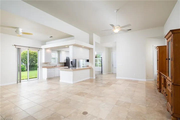 Kitchen with a peninsula, white cabinetry, open floor plan, and light countertops