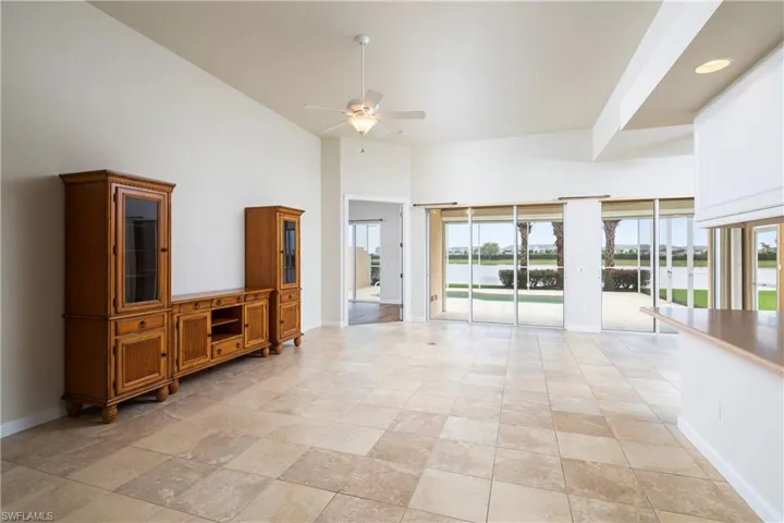 Great room with lake water view, high vaulted ceiling, opens up to pool lanai