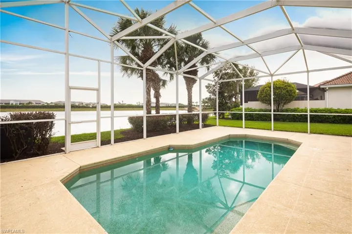 Pool featuring a lanai, a water view, and a patio