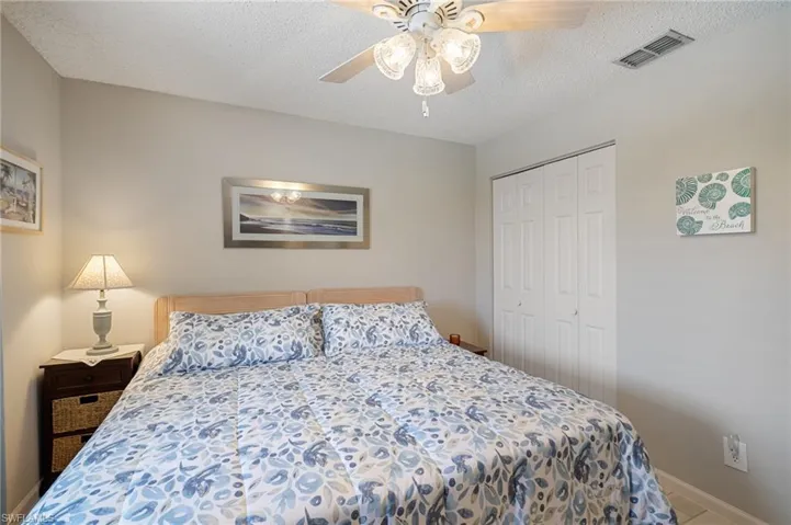 Bedroom featuring a textured ceiling, a closet, and ceiling fan