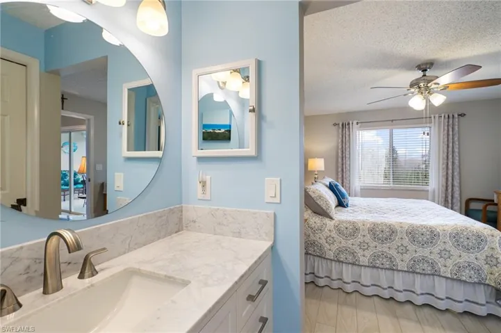 Bedroom with ceiling fan, sink, and a textured ceiling