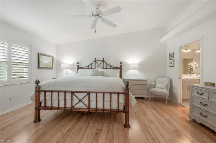 Primary Bedroom with wood flooring. and en-suite bath