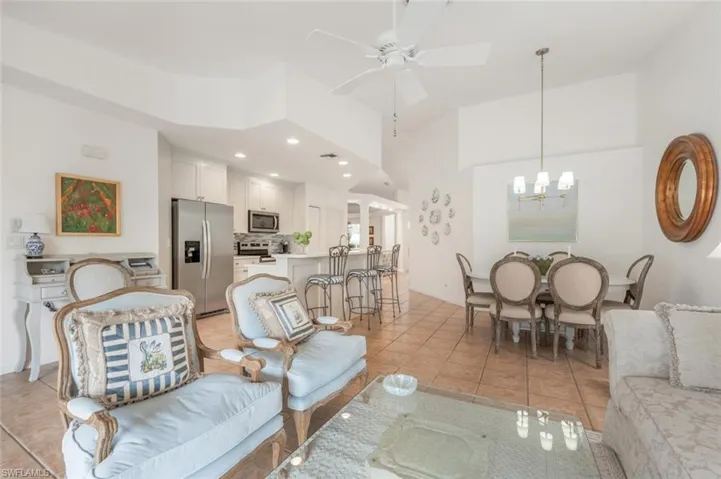 Living room featuring decorative columns, light tile patterned  recessed lighting and chandelier